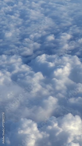 Beautiful cloudscape. Panorama above white clouds as seen through window of an aircraft. A view from airplane