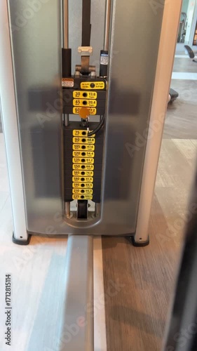 Weights on the weight stack rising and falling from the inner outer thigh machine