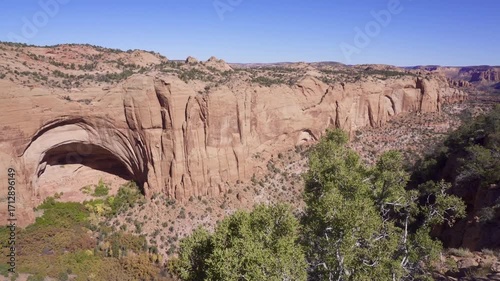 Navajo National Monument in Navajo Nation territory, Arizona. Betatakin ruins in Betatakin Canyon with autumn aspen. One of three well-preserved cliff dwellings of the Ancestral Puebloan people.