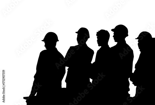 A group of construction workers in profile view, wearing hard hats, are engaged in a discussion.