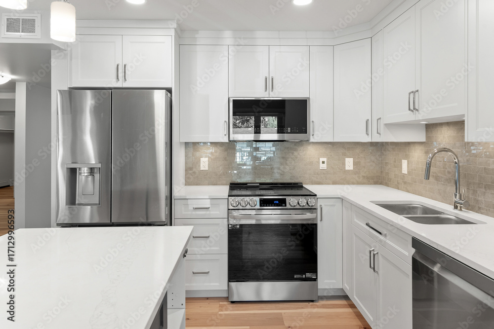 Fototapeta premium Clean and modern kitchen with a stainless steel refrigerator, microwave