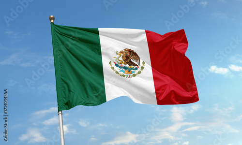 Mexico national flag waving against clear blue sky with eagle and snake emblem in center