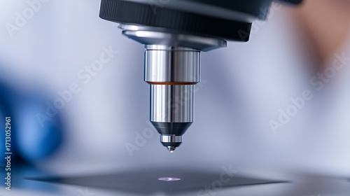 Wallpaper Mural Close-up of a laboratory microscope. The objective lens is focused on a sample, highlighting scientific research and analysis. Torontodigital.ca