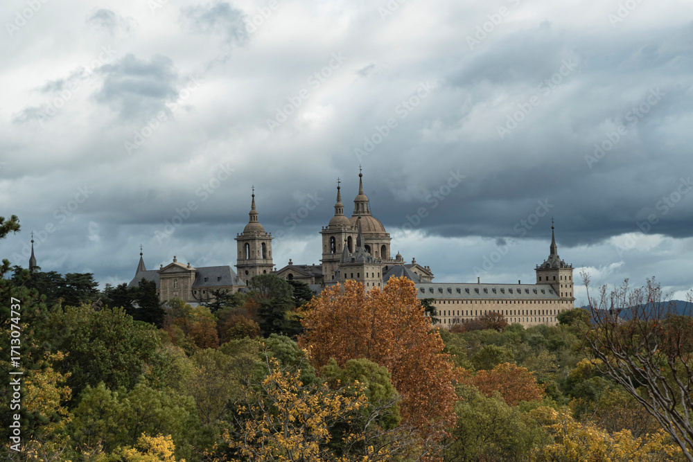 Fototapeta premium views of the Monastery of El Escorial and its historic gardens surrounded by autumn trees and spectacular skies.