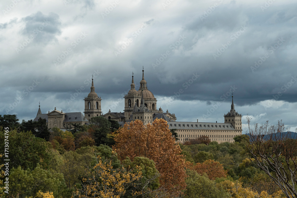Obraz premium views of the Monastery of El Escorial and its historic gardens surrounded by autumn trees and spectacular skies.