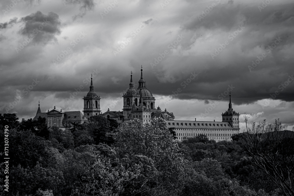 Obraz premium views of the Monastery of El Escorial and its historic gardens surrounded by autumn trees and spectacular skies.