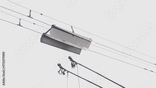 An electric trolleybus extends its poles to connect with the overhead wires, seamlessly switching from battery to grid power while in motion.