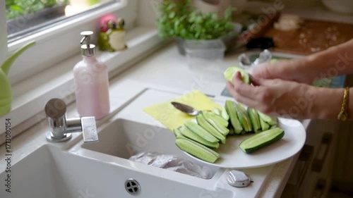 Woman preparing fresh vegetables for homemade family meal in bright kitchen. Closeup of hands cutting healthy food near window with natural light.