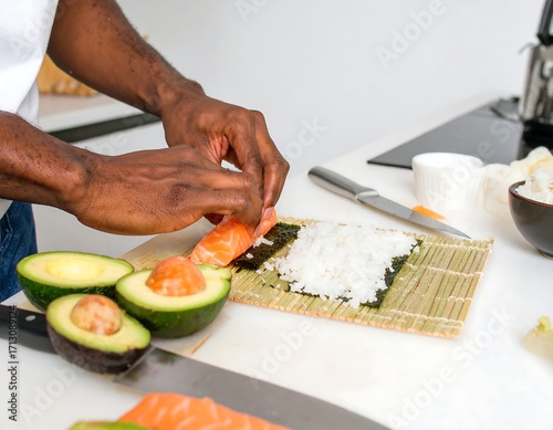 Person making sushi rolls