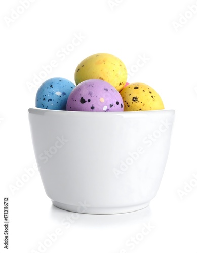 A white bowl brimming with colorful, speckled Easter eggs against a plain white background.