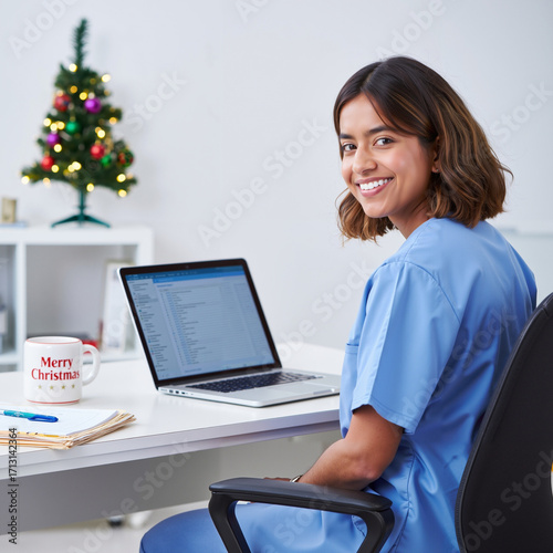 Nurse with cheerful mood working at desk against Christmas tree and office background 