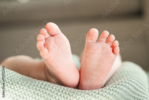 Bild auf Leinwand bottom of white newborn baby feet on a soft green blanket