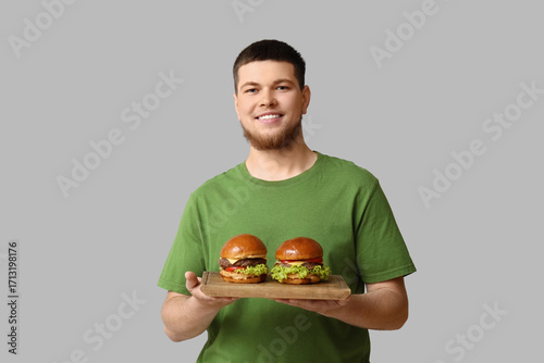 Young man holding board wit...
