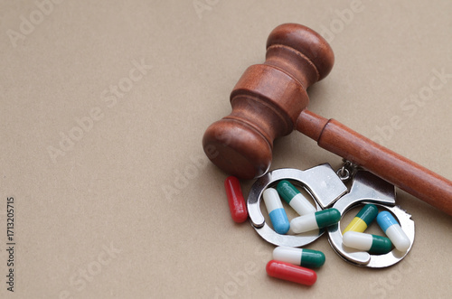 A stark composition of handcuffs and pharmaceutical drugs, symbolizing the complex legal and ethical issues surrounding controlled substances, healthcare regulation, and medical justice.