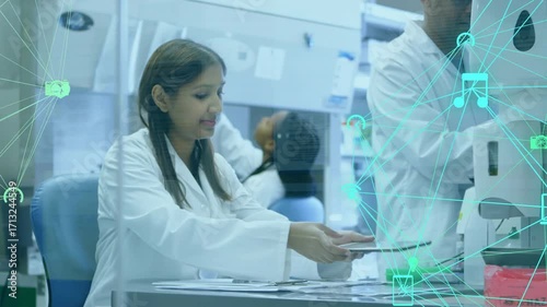 Lab scientist sorting papers lifting tablet and tapping screen visualizing data for research