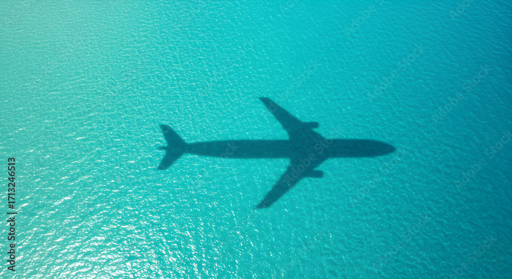 Fototapeta premium Airplane Shadow Cast Over Vibrant Turquoise Tropical Waters Creating Striking Visual Contrast