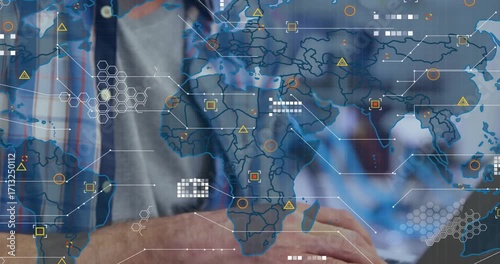 Developer typing on laptop in tech office, activating animated world map with live data nodes