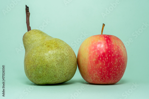 pear and apple close up on plain green background