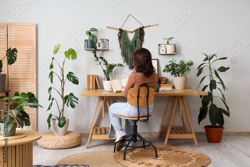 Young woman reading book at...