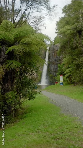 Hunua Falls in Hunua Range Regional Park, New Zealand. Tourists visit the waterfall, a popular destination for hiking and enjoying nature.