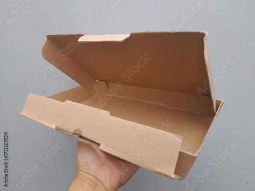 Open brown cardboard box on gray background, ready for packing or shipping