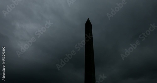 Dark storm clouds pass behind the Washington Monument in Washington, DC, USA.