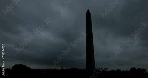 Dark storm clouds pass behind the Washington Monument in Washington, DC, USA.