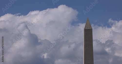 Beautiful puffy clouds pass on a blue sky behind the Washington Monument on a beautiful day in Washington, DC, USA.