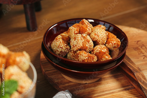 Foto Crispy Sesame Balls Guangxi Chinese Deep Fried Dessert Specialty in Dark Bowl on