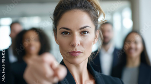 Wallpaper Mural Confident businesswoman pointing directly at camera with team behind. 
 Torontodigital.ca