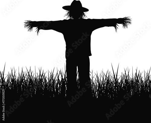Black scarecrow silhouette arms outstretched in grass
