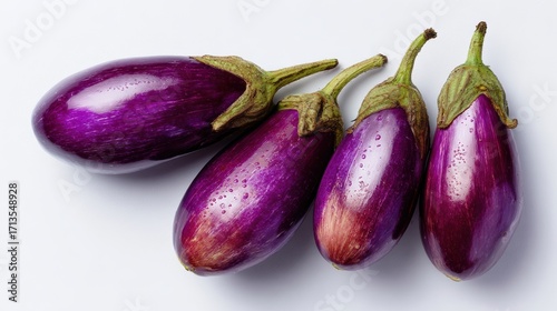 Wallpaper Mural Fresh, vibrant eggplants arranged on a white background, showcasing their glossy purple skin and unique shapes. Torontodigital.ca