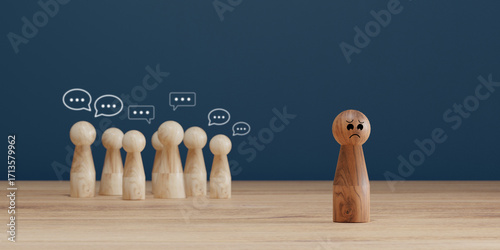 Sad wooden figure excluded from group. Concept of bullying, discrimination, isolation, loneliness, and mental health in society, workplace or school.