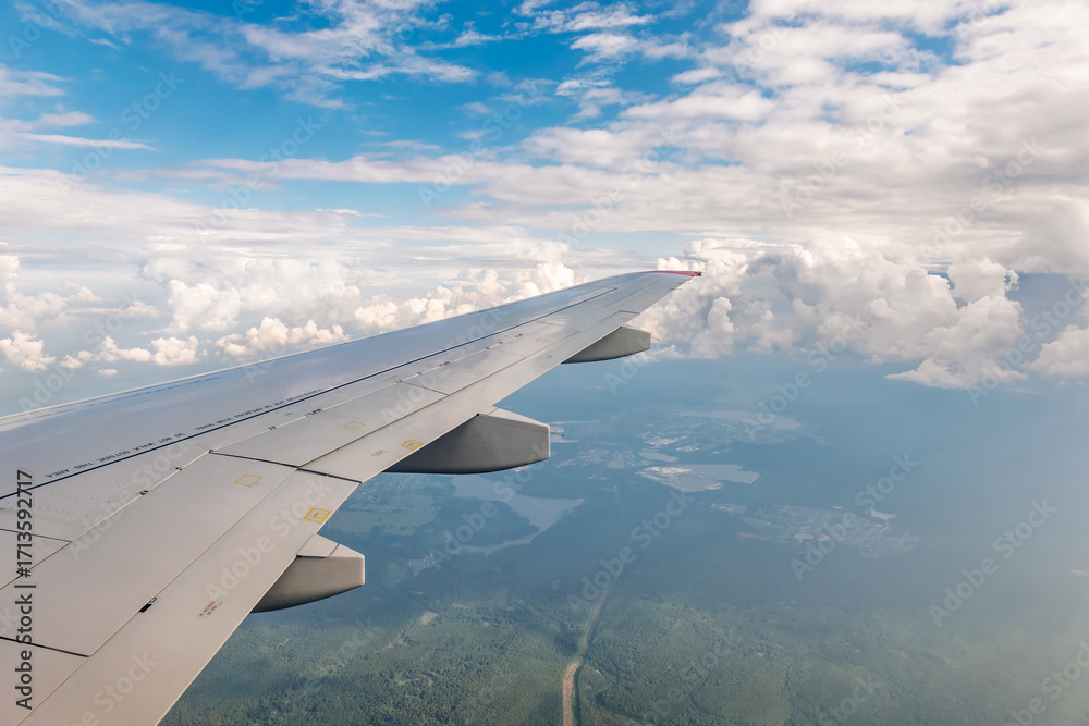 Obraz premium View from the airplane window at a beautiful cloudy sky and the airplane wing