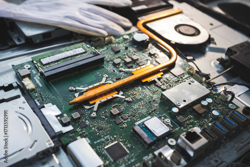 Close-up image of an all-in-one computer interior showing the motherboard, heat pipe cooling system, RAM slot, processor, and electronic components. Inside View of All-in-One Computer Motherboard