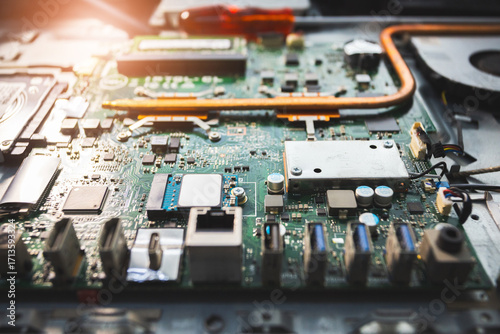 Close-up image of an all-in-one computer interior showing the motherboard, heat pipe cooling system, RAM slot, processor, and electronic components. Inside View of All-in-One Computer Motherboard