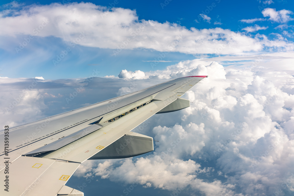 Obraz premium View from the airplane window at a beautiful cloudy sky and the airplane wing