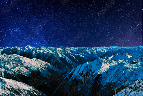 night view of snowy mountain range and milky way. starry night sky with stars and moon. beautiful landscape with snowy mountain peaks in winter night.