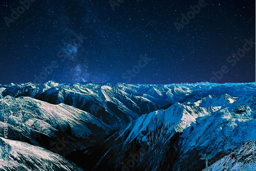night view of snowy mountain range and milky way. starry night sky with stars and moon. beautiful landscape with snowy mountain peaks in winter night.