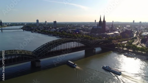 Skyline view featuring an arched bridge, riverboats, cathedral, and cityscape