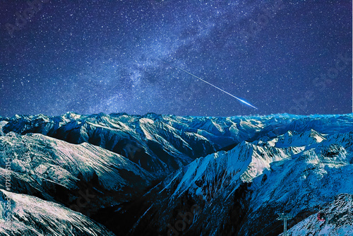 night view of snowy mountain range and milky way. starry night sky with stars and moon. beautiful landscape with snowy mountain peaks in winter night.