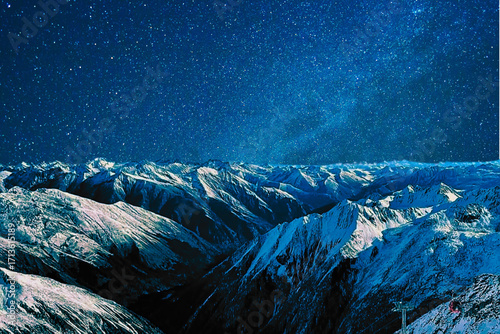 night view of snowy mountain range and milky way. starry night sky with stars and moon. beautiful landscape with snowy mountain peaks in winter night.