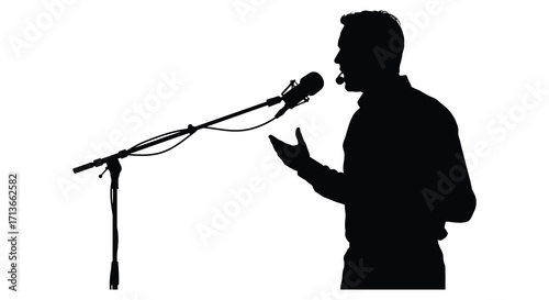 Silhouette of a man speaking into a microphone on stage
