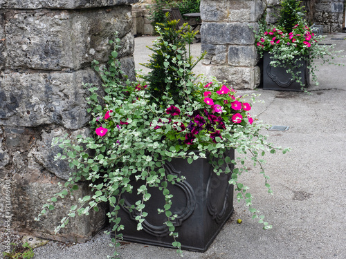 Elegant Flower Arrangements in Stone Planters Against Rustic Brick Walls