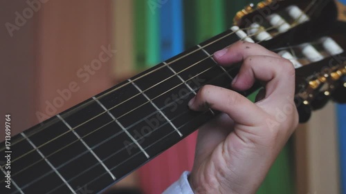 A schoolboy, covered in ink, plays classical guitar in slow motion. Music school, children's extracurricular activities, and creativity.
