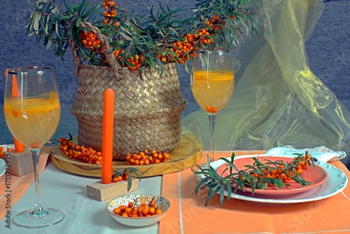 Sea buckthorn branches and sea buckthorn juice on the table