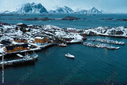 Snowy Coastal Village with Boats and Mountains