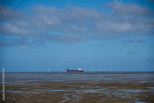 Frachtschiff vor einer Offshoreanlage in der Nordsee