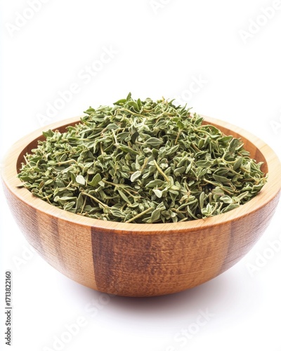A wooden bowl filled with fragrant dried oregano leaves, showcasing their vibrant green color and texture.