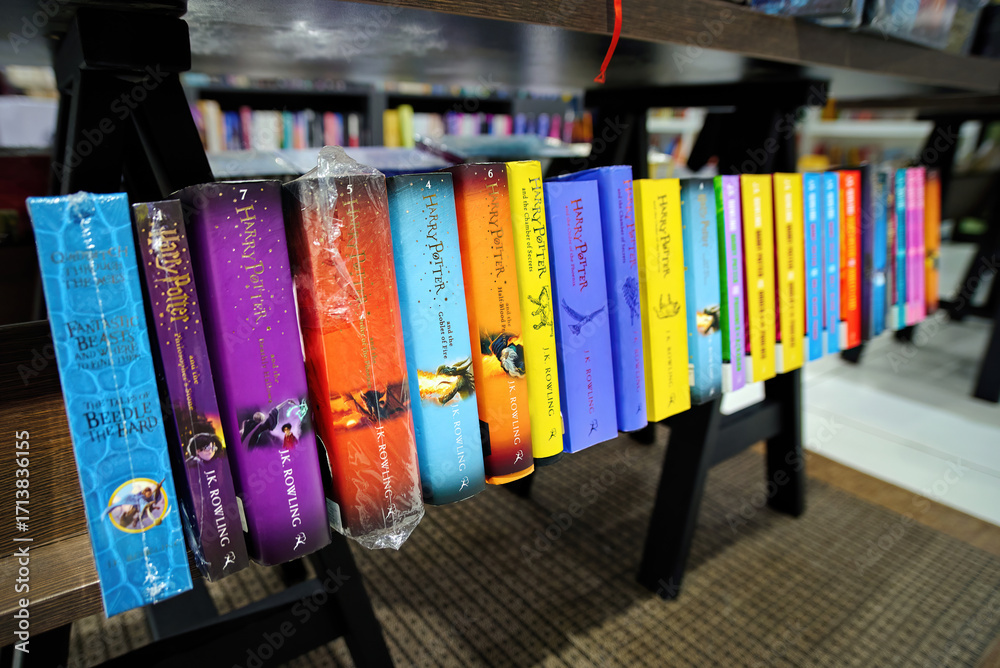 Naklejka premium Minsk, Belarus. Jan 12, 2025. Harry Potter books collection displayed on bookshelf, english editions of fantasy novels written by J.K. Rowling arranged for retail and literature fans. Selective focus